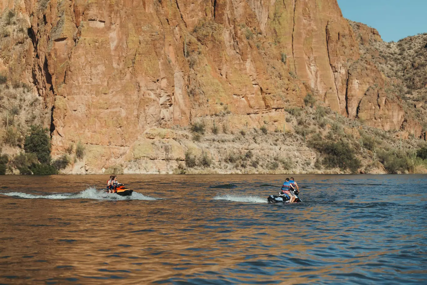 Two jet skis riding together beneath the cliffs at Canyon Lake